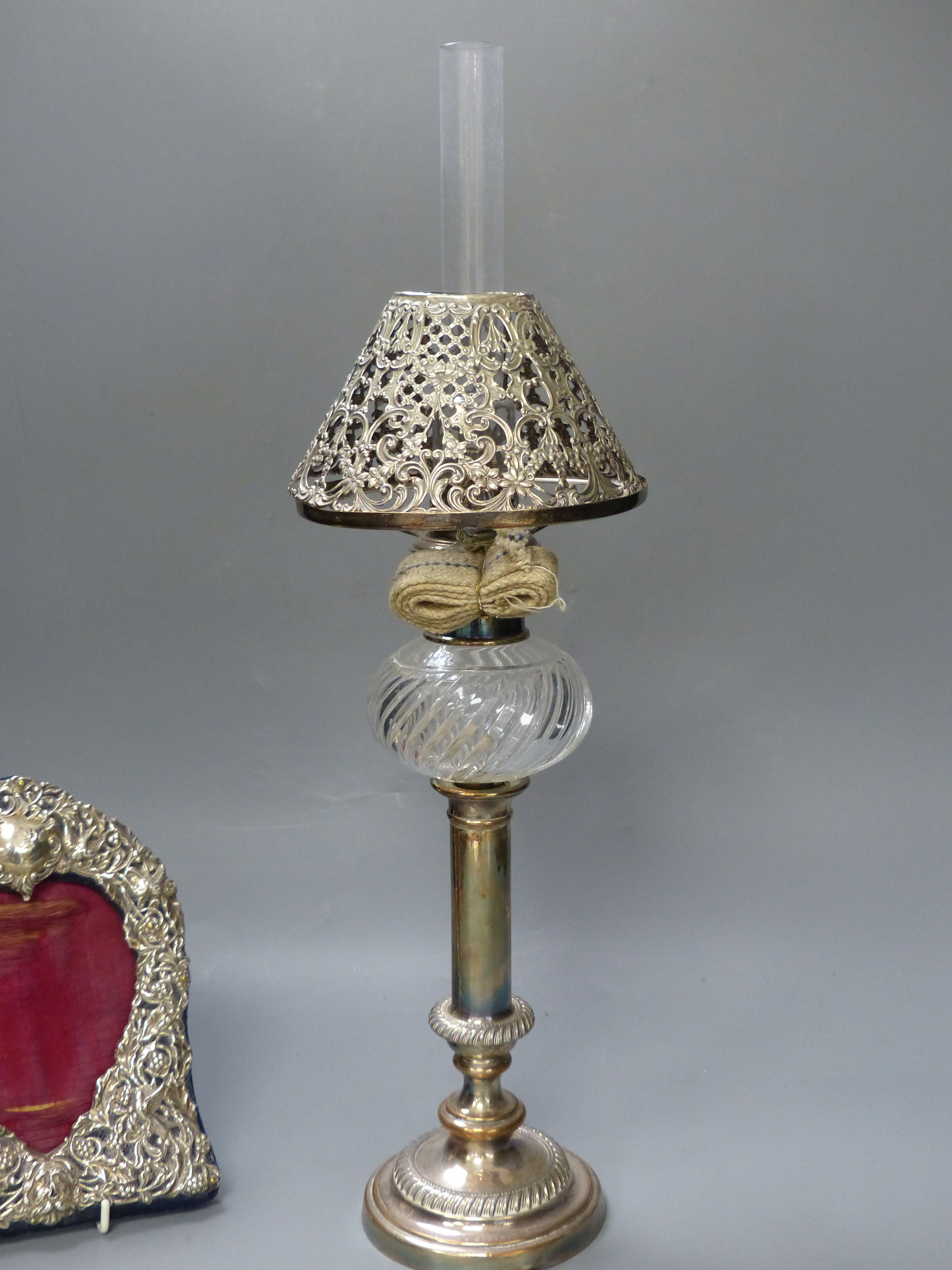 A Victorian plated oil lamp with white metal shade together with a Victorian silver mounted frame